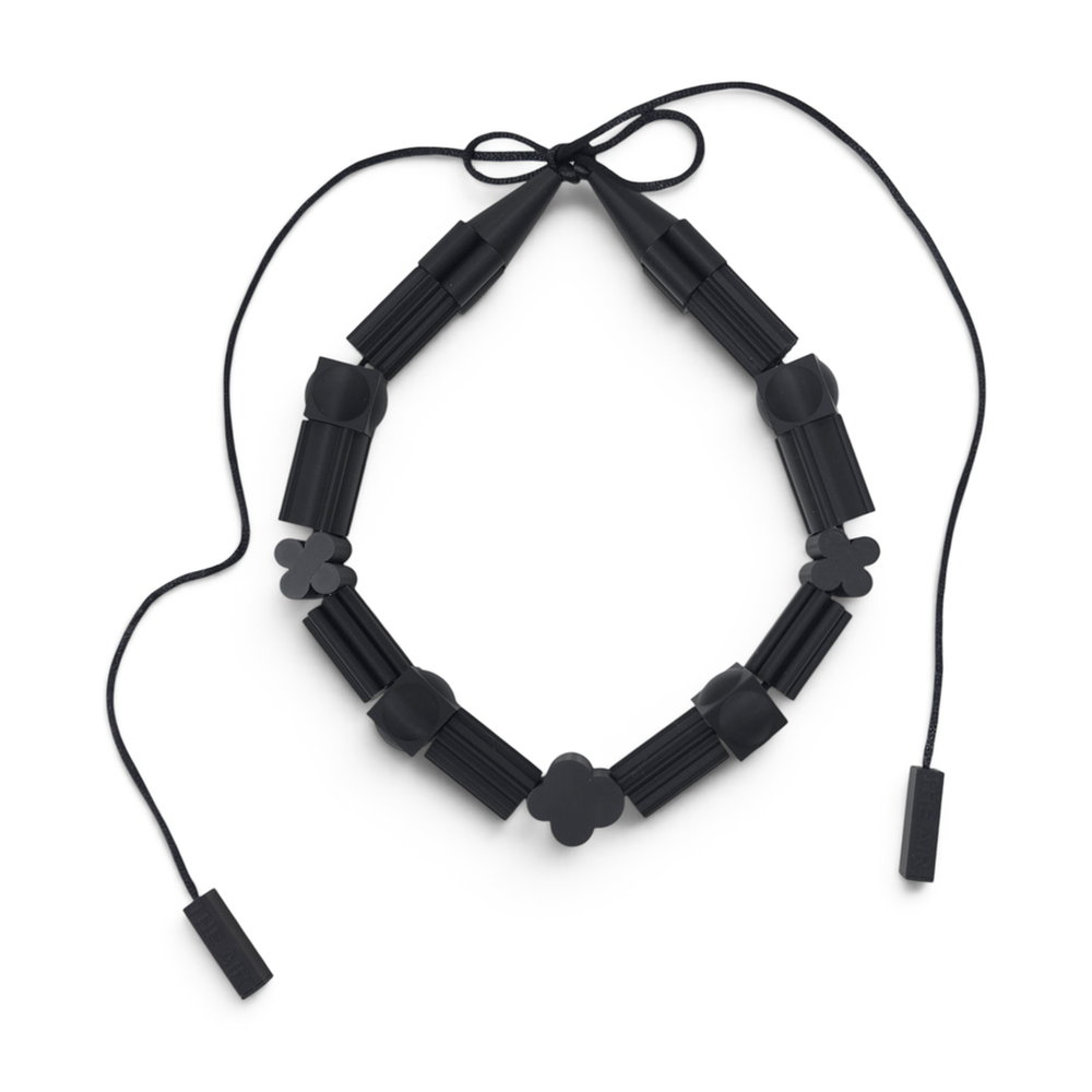 THE AIR Salmiakki black necklace arranged on a pure white background
